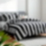 A stylish black and white vertical striped comforter on a modern bed frame.