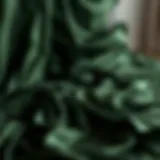 Luxurious dark green satin sheets draping elegantly over a bed